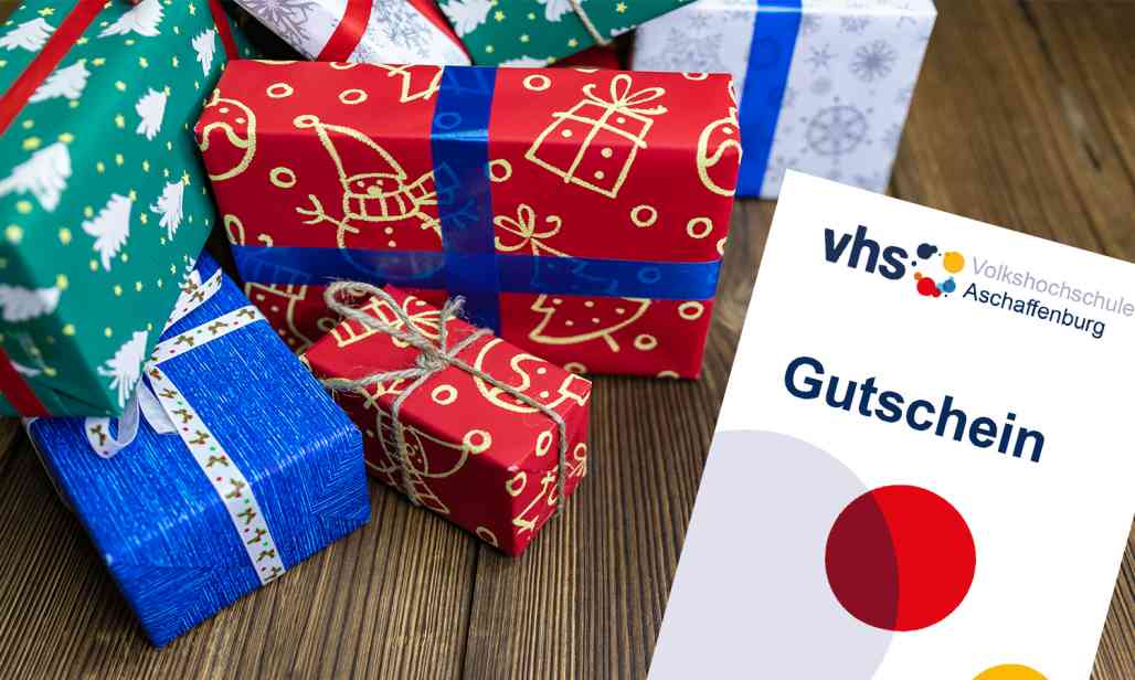 Päckchen in Weihnachtspapier verpackt und ein Geschenkgutschein der vhs Aschaffenburg