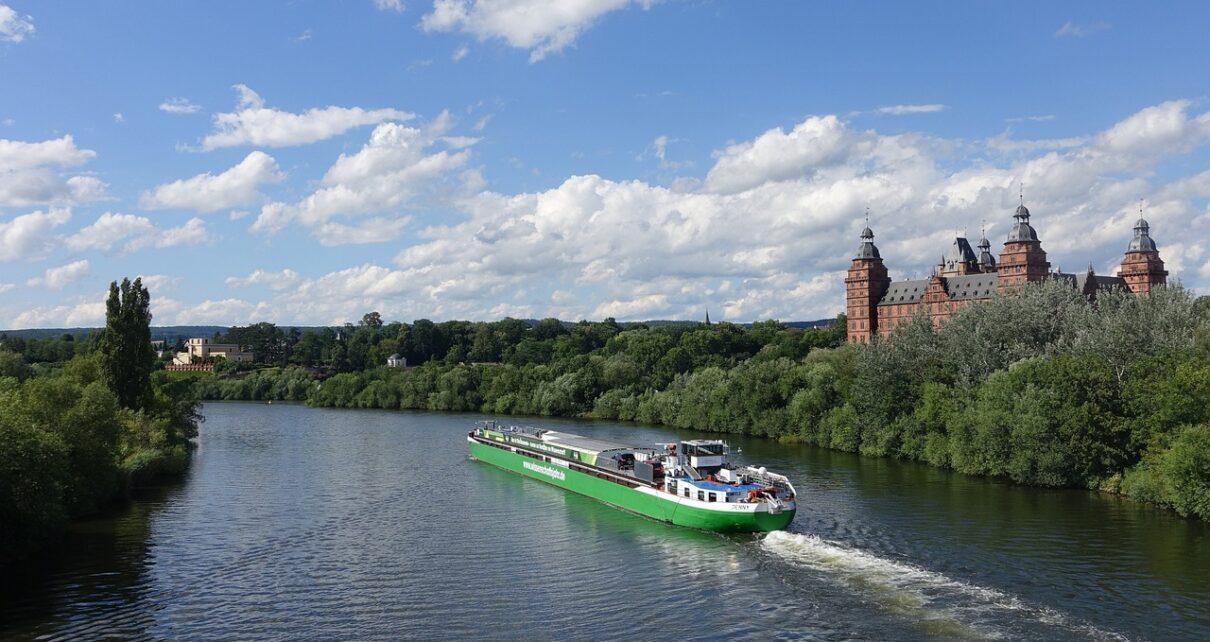 Blick auf den Main mit einem Schiff, im Hintergrund das Aschaffenburger Schloss