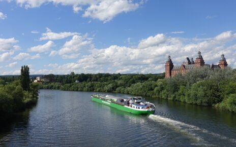 Blick auf den Main mit einem Schiff, im Hintergrund das Aschaffenburger Schloss