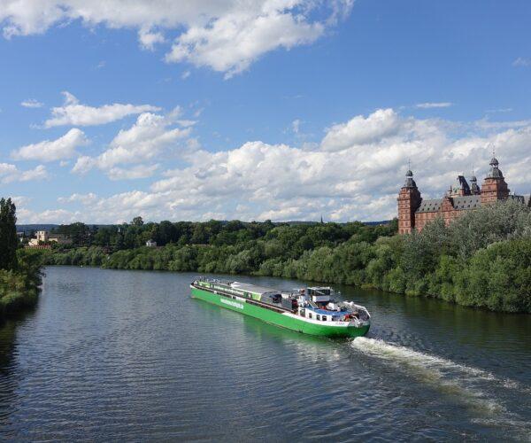 Blick auf den Main mit einem Schiff, im Hintergrund das Aschaffenburger Schloss