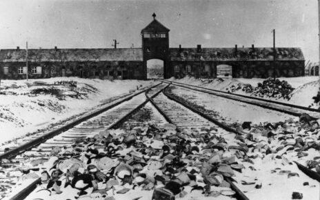 Konzentrationslager Auschwitz, Polen 1945. Lagertor (innen) / Ausfahrt nach der Befreiung, im Vordergrund von den Wachmannschaften zurückgelassene Ausrüstungsgegenstände.