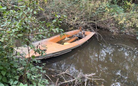 Halb gesunkene orangefarbene Segeljolle in der Aschaff – Segeljolle Hösbach